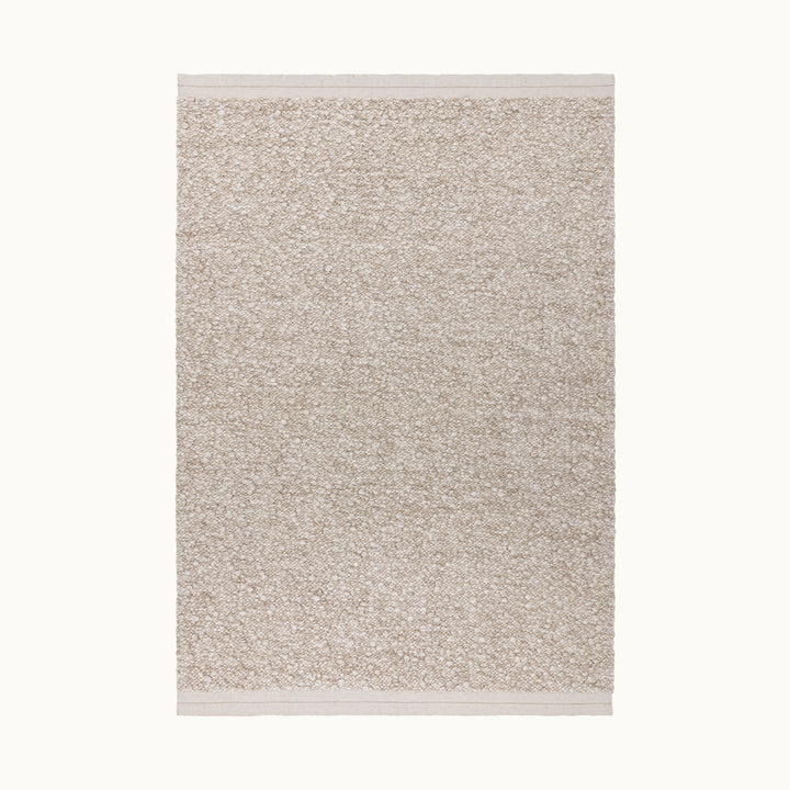 160x230cmサイズの羊毛そのままのようなベージュの暖かな色合いと、ブークレ（Boucle）織りのざっくりとした風合いがパーフェクトにマッチした、RUGHAUSの手織りのシンプルモダンラグ