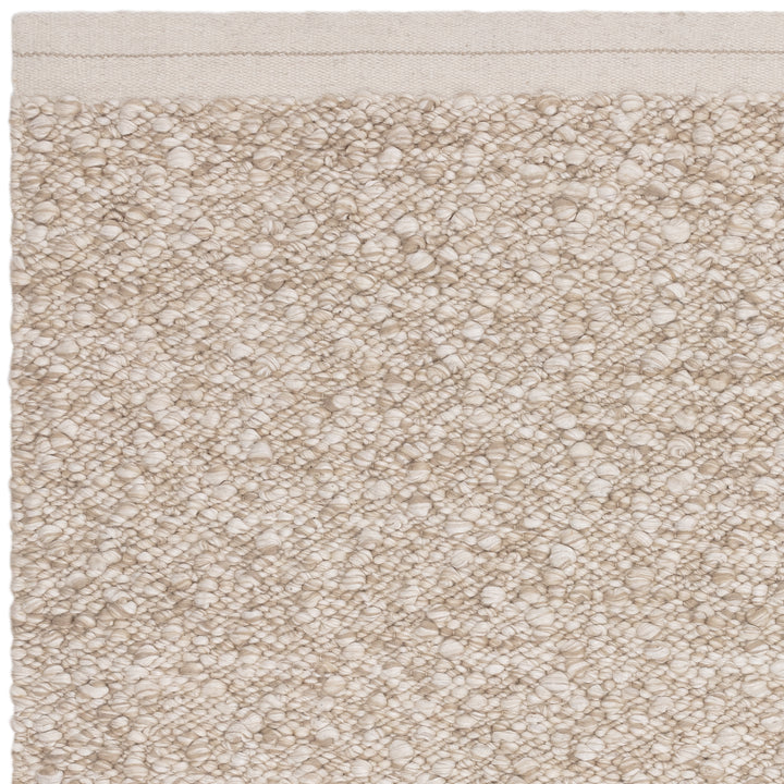 羊毛そのままのようなベージュの暖かな色合いと、ブークレ（Boucle）織りのざっくりとした風合いがパーフェクトにマッチした、RUGHAUSの手織りのシンプルモダンラグの素材感がわかるクロースアップ