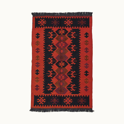 120x180cmサイズの情熱的な赤と伝統的な部族模様の組み合わせがエナジェティックな印象を与える、ブラック×レッドのリバーシブル仕様のハンドメイドトライバルラグ