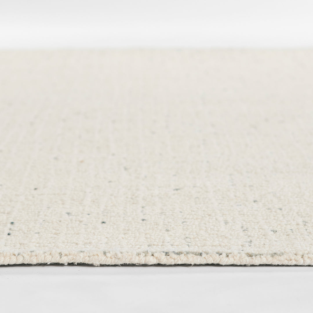 アイボリー × グレーの羊毛が美しく織り混ざった、ニュートラルな色合いが素敵な、RUGHAUSの天然素材ウール100％製ハンドタフテッドラグの素材感がわかるクロースアップ